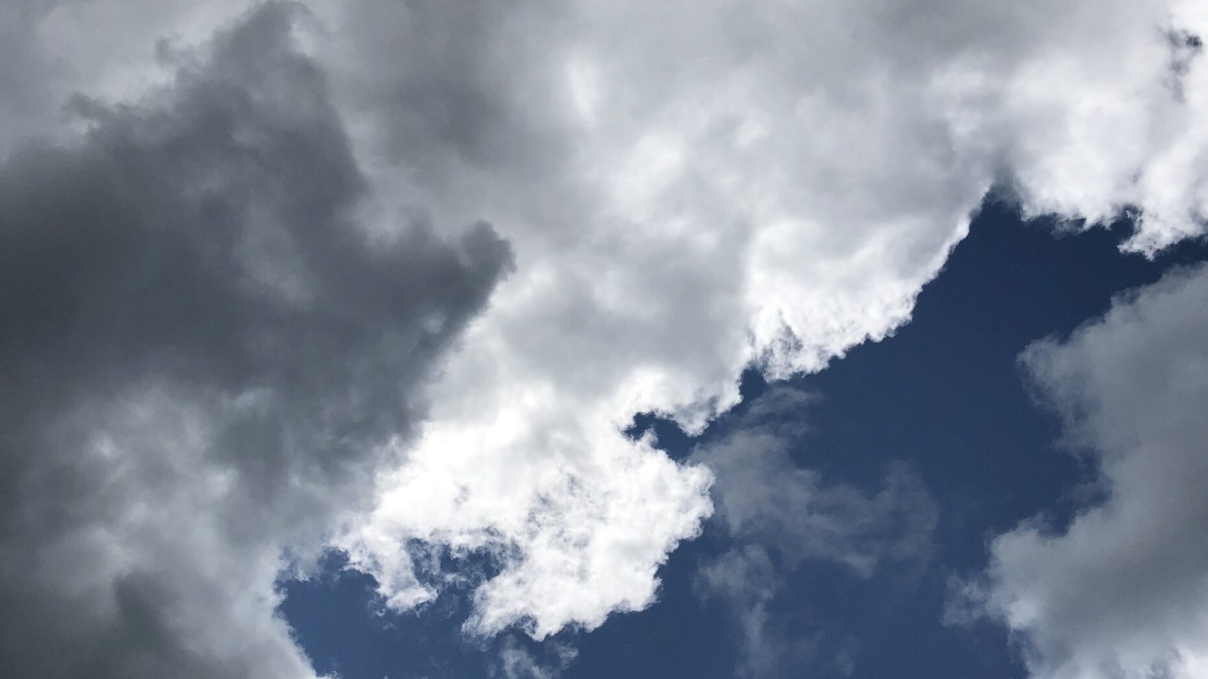 Dark and light clouds against a dark blue sky representing waiting for hope while going through endometriosis.